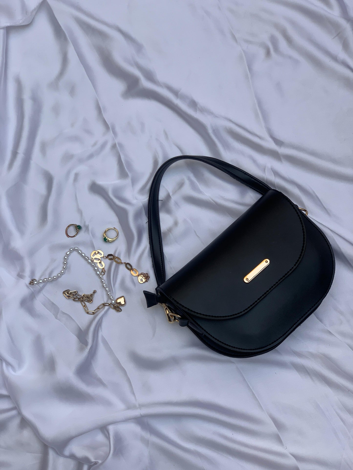 Sleek black handbag with long strap