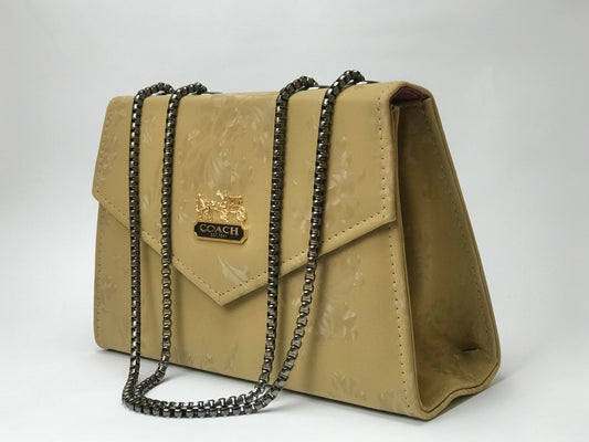 pastel yellow handbag with chain strap on a white background